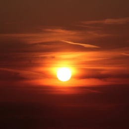 sun setting behind clouds